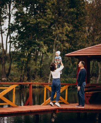 young-family-with-little-son-walking-bridge-by-river-scaled.jpg